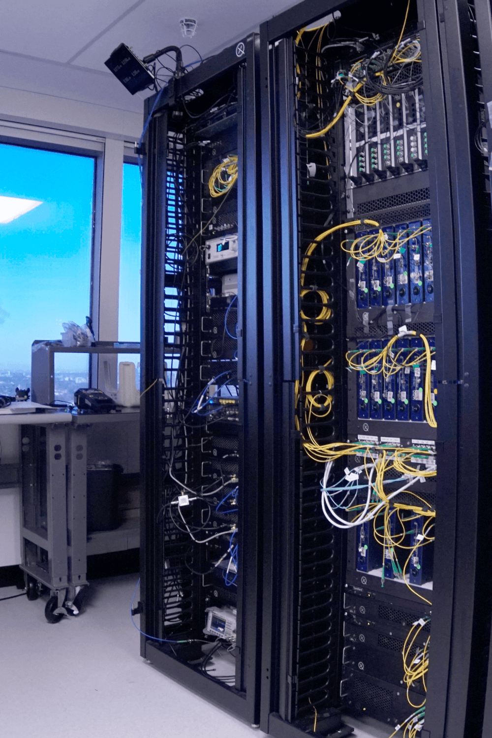 Racks of photonic quantum computing modules, cabled with optical fiber, in Xanadu's Toronto lab